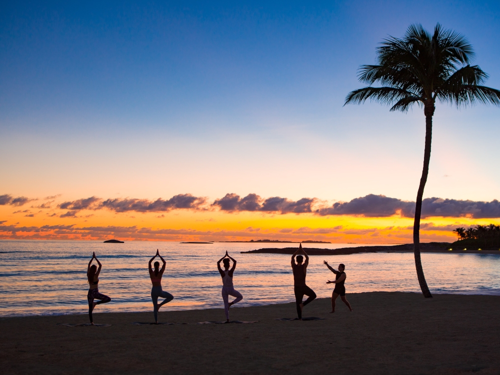 A group doing yoga on the beach in Nassau