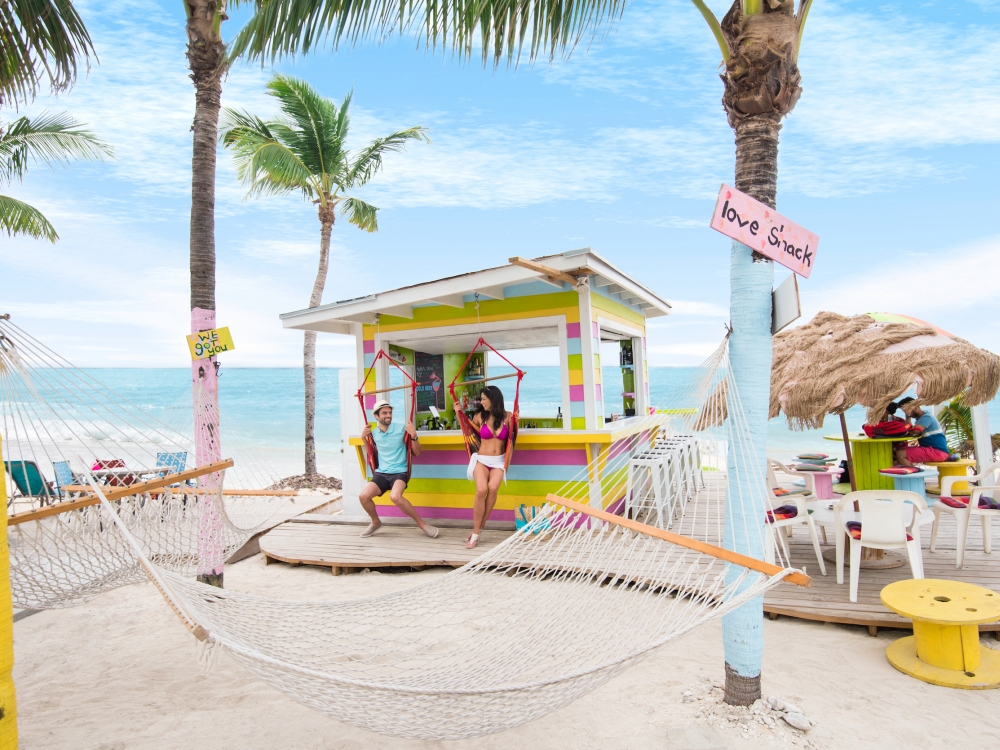 A couple sits on a hammock at Junkanoo beach in The Bahamas. 